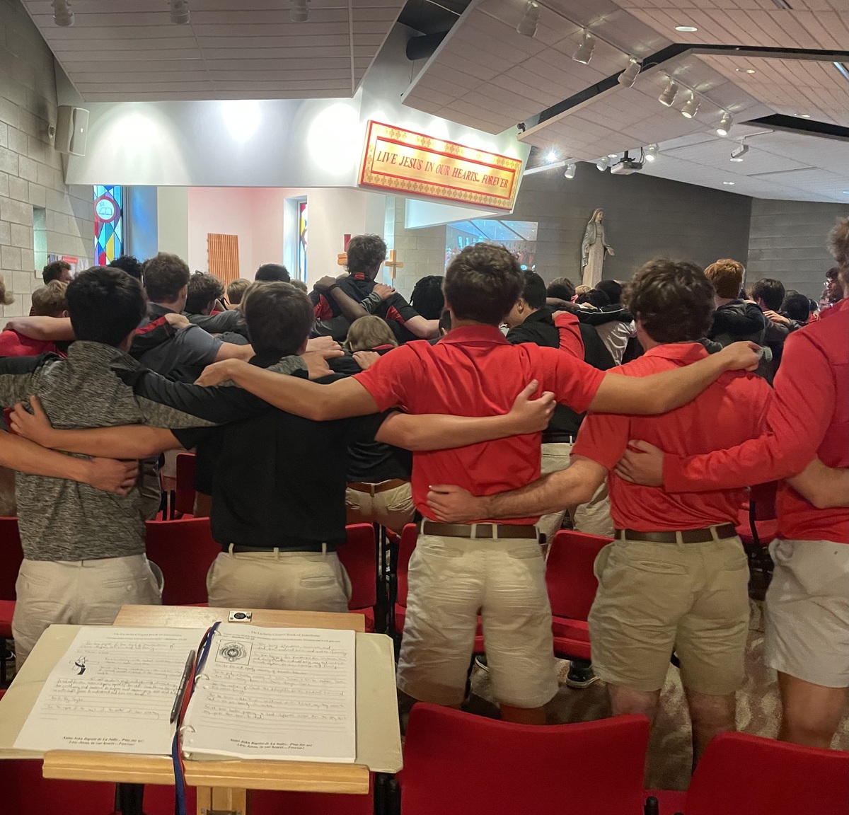 Students arm-in-arm in gym