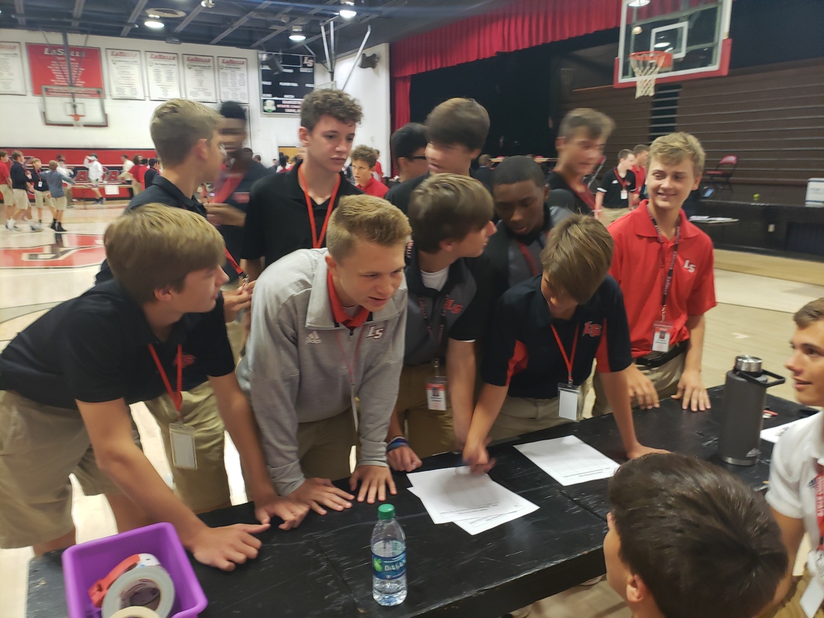 Students stand in line at tables
