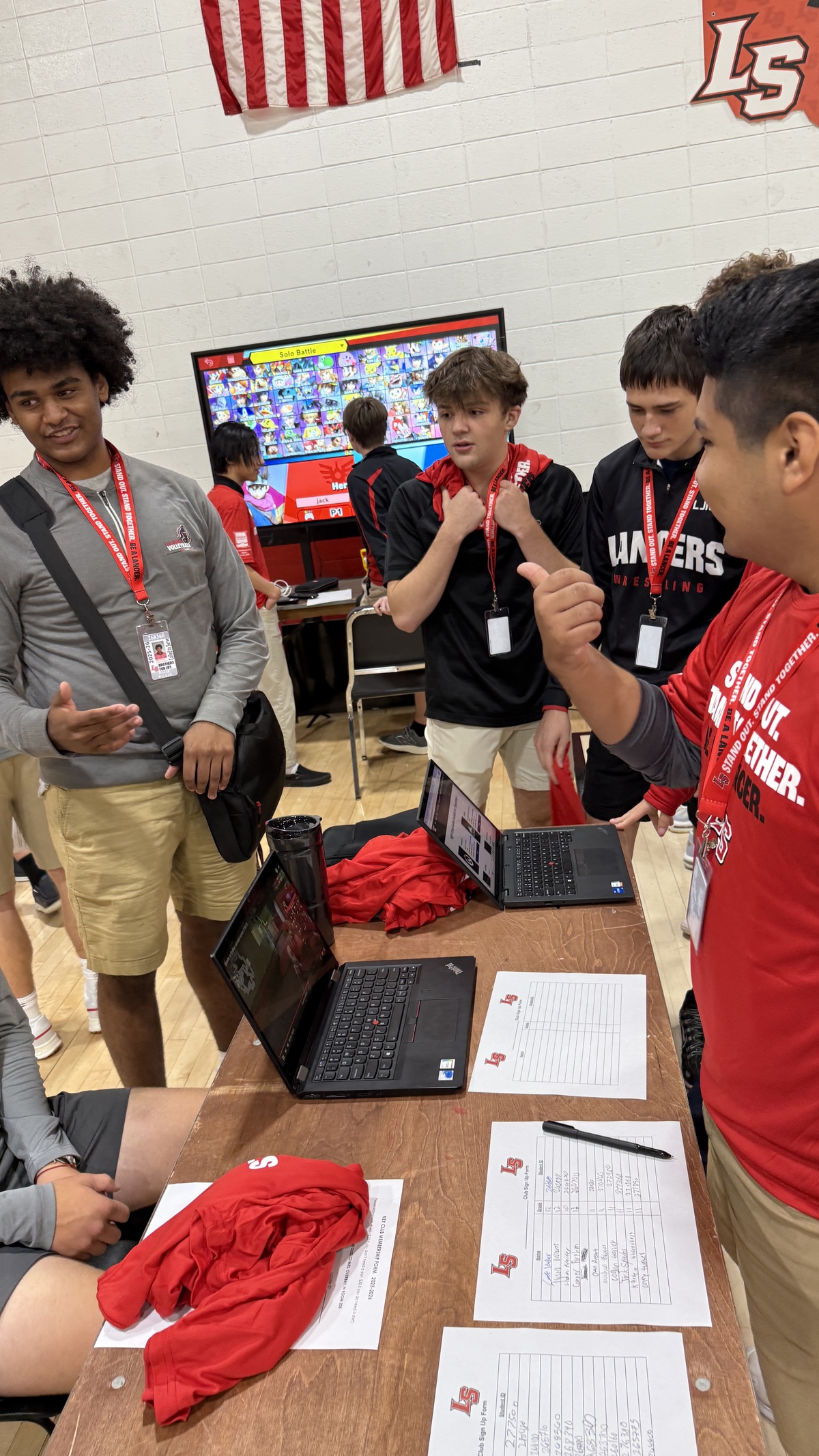 Students stand in line at tables