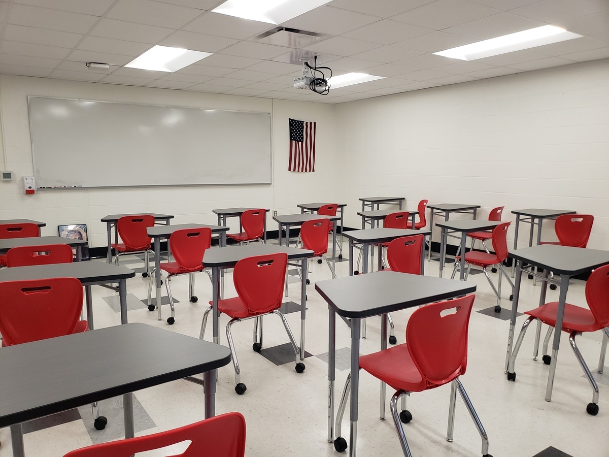 desks and red chairs in classroom