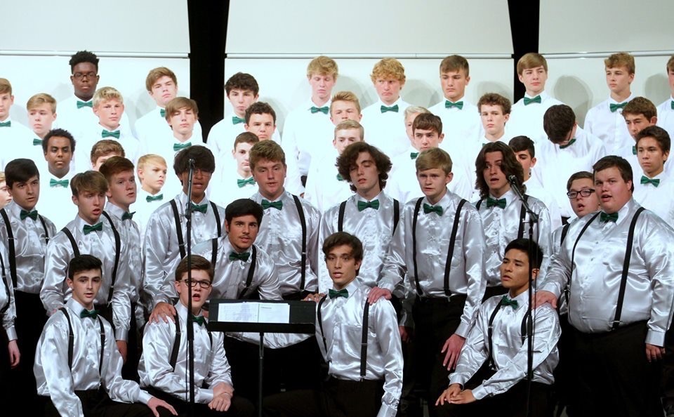 Choir in bowties and white shirts on stage